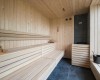Dřevěná sauna s lavicemi a kamny.