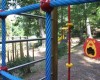 Dětské hřiště v parku s prolézačkami a tunelem ve tvaru lva.