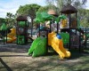 Dětské hřiště s barevnými skluzavkami a atrakcemi ve tvaru zvířat v parku.