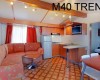 Interiér mobilního domu s kuchyňským koutem, sedací soupravou a nápisem M40 TREND.