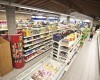 Interiér supermarketu s regály plnými potravin a nápojů.