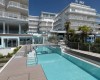 Moderní hotel s venkovním bazénem a palmami.