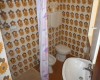 Koupelna s retro květinovými dlaždicemi, sprchovým koutem, umyvadlem a toaletou.  