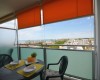 Balkon s výhledem na město a moře, kulatý stůl se dvěma židlemi.