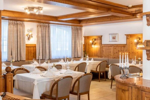 Restaurace s dřevěným interiérem a prostřenými stoly.
