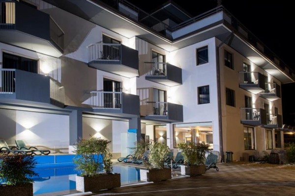 Moderní hotel s terasami osvětlený v noci.