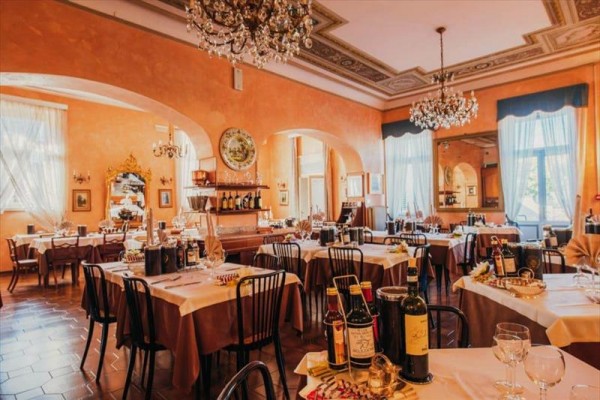 Elegantní restaurace s prostřenými stoly a lustry na stropě.