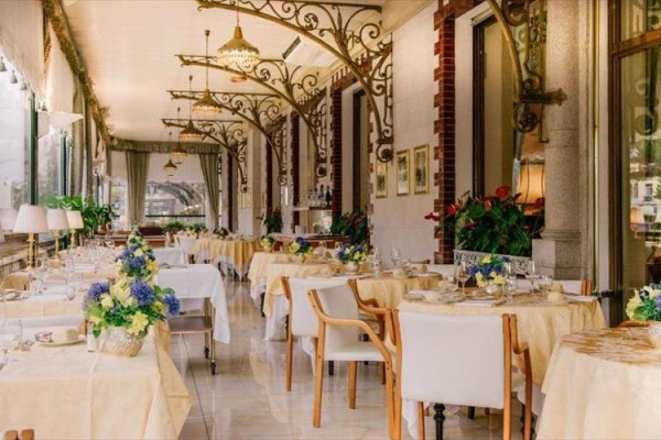 Elegantní interiér restaurace s bílými ubrusy a květinovou výzdobou.
