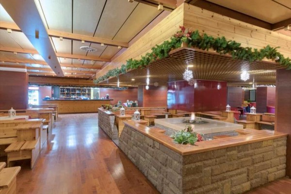 Interiér restaurace s dřevěným nábytkem a vánoční výzdobou.