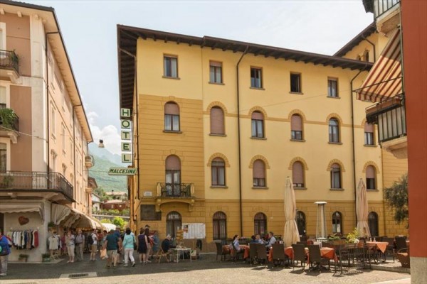 Starý hotel s venkovní kavárnou na náměstí.