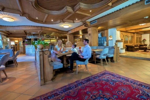 Rodina u stolu v restauraci s dřevěným interiérem.