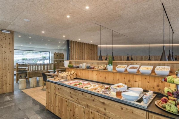 Bufetová nabídka v dřevěném interiéru restaurace se saláty, chlebem a cereáliemi.