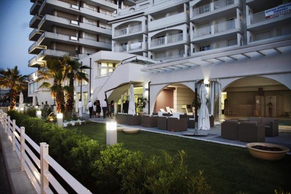 Moderní venkovní prostor u hotelu s pohodlným posezením a palmami.
