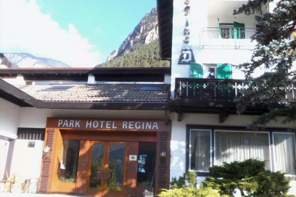 Vchod do hotelu Park Hotel Regina s horami v pozadí.