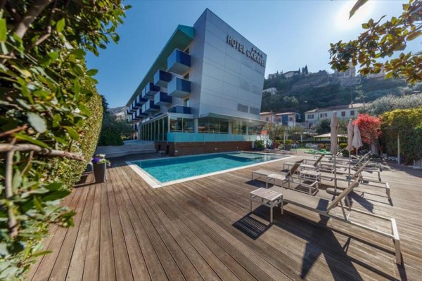 Moderní hotel s venkovním bazénem a terasou obklopenou lehátky.