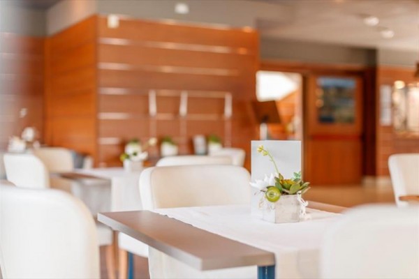 Moderní interiér restaurace s dřevěnými obklady a světlým nábytkem.