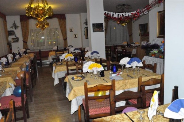 Slavnostně prostřená restaurace s balonky a dekoračními ubrusy.