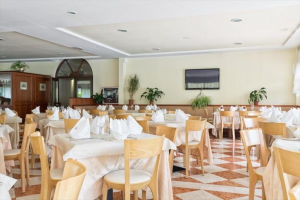 Restaurace s prázdnými stoly a nastavenými bílými ubrusy a ubrousky.