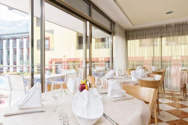 Restaurace s prostřenými stoly u velkých skleněných oken s výhledem ven.