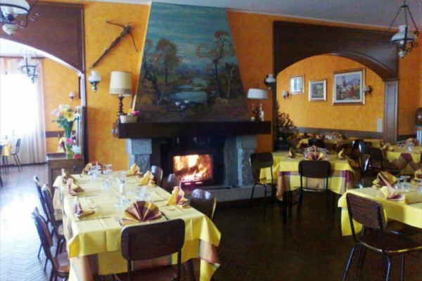 Restaurace s krbem a prostřenými žlutými stoly.  