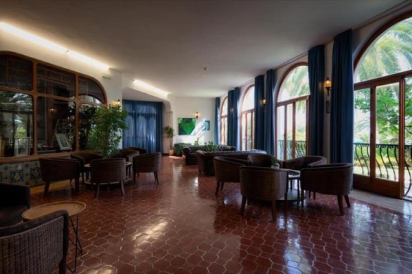 Elegantní hotelová lobby s velkými okny a pohodlnými křesly.