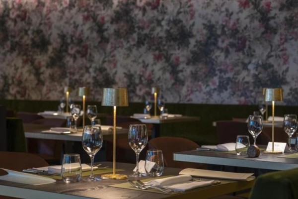 Restaurace s elegantně prostřenými stoly a jemným osvětlením.