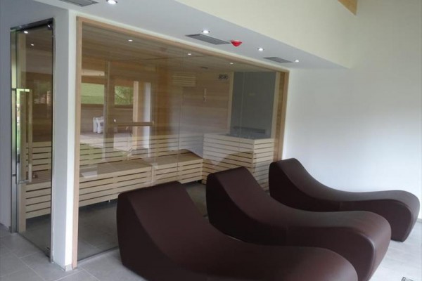 Sauna s třemi hnědými lehátky na odpočinek.