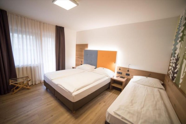 Hotelový pokoj s manželskou postelí a samostatným lůžkem.
