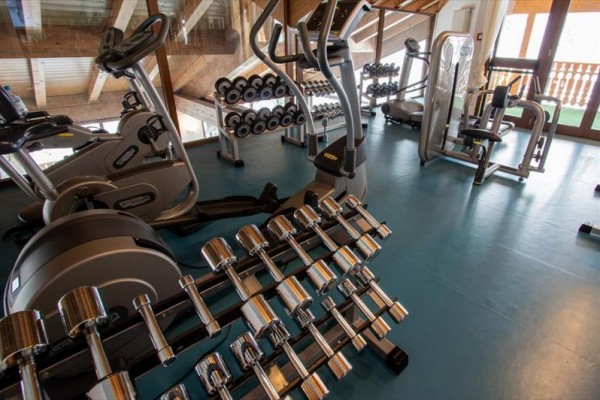 Posilovna s činkami a fitness stroji.