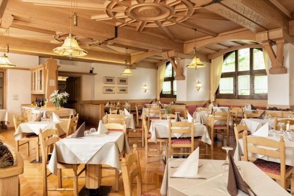 Restaurace s dřevěným stropem a prostřenými stoly.