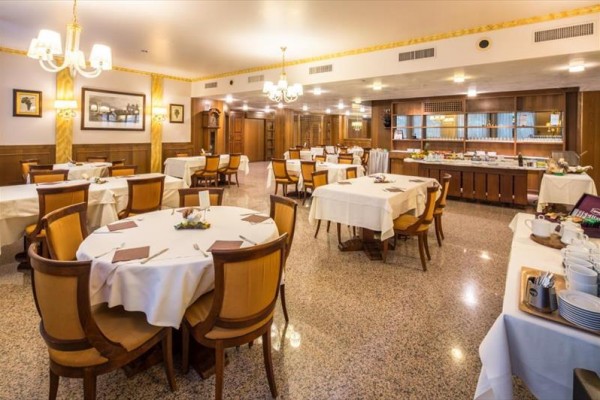 Luxusní restaurace s dřevěným nábytkem a prostřenými stoly.