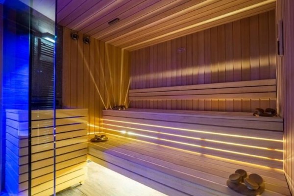 Moderní sauna s dřevěným obložením a osvětlením.