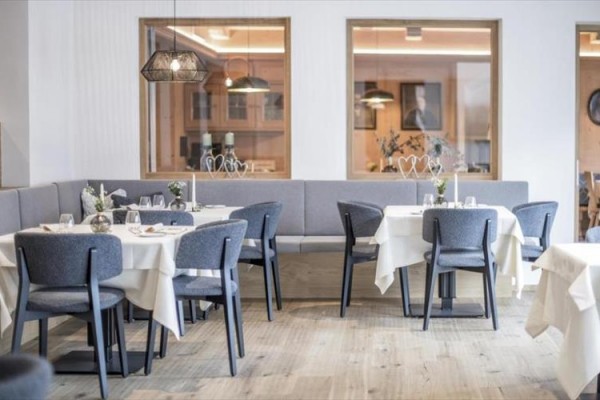 Moderní restaurace s šedými židlemi a prostřenými stoly.