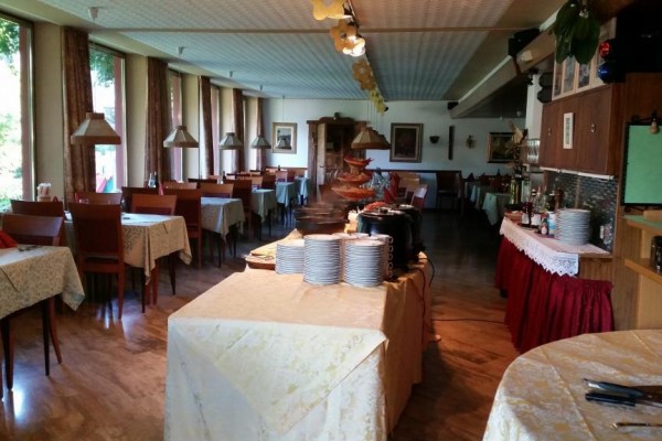 Restaurace s prostřenými stoly a bufetovými stanicemi.