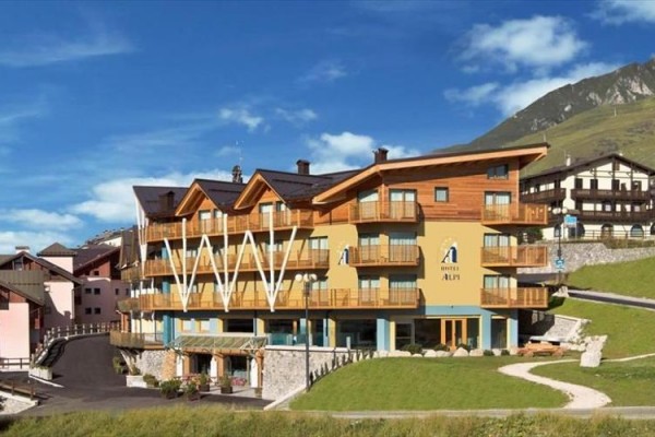 Hotel s dřevěným obložením a balkony v horské krajině.