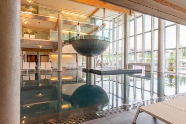 Vnitřní bazén se skleněnými stěnami a moderními architektonickými prvky.