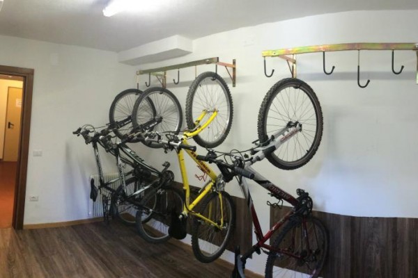 Cyklistická místnost s pěti koly zavěšenými na stěně.