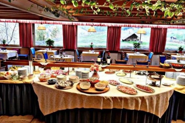 Bufetový stůl s různými jídly v prosvětlené restauraci.