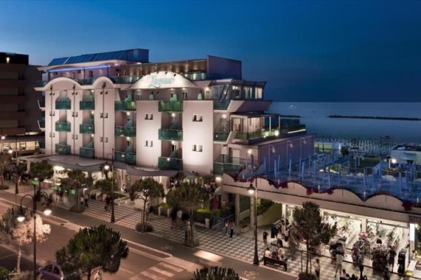 Moderní hotel u moře ve večerním osvětlení.