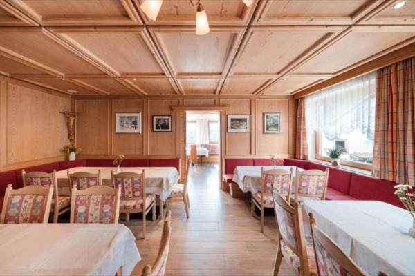 Restaurace se světlým dřevěným obložením a červenými lavicemi.