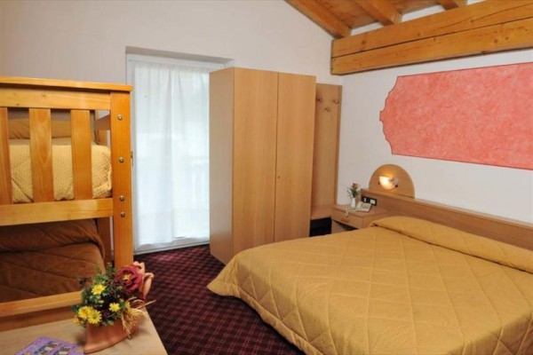 Ložnice s manželskou postelí, palandou, skříní a dřevěným stropem.  