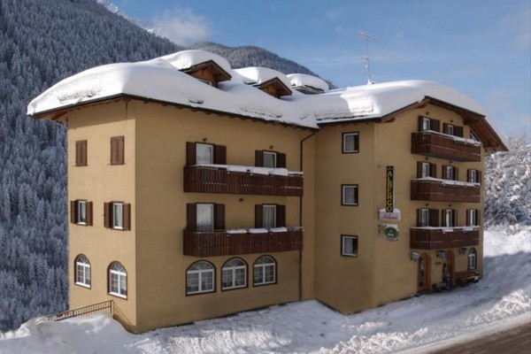 Třípatrový hotel v zasněžené horské krajině.