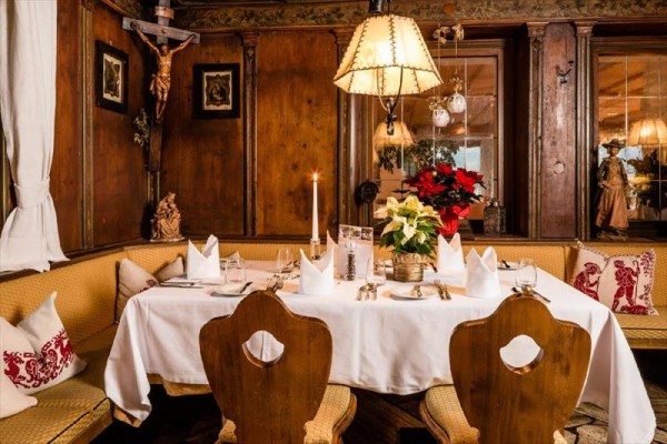 Stylově zařízený interiér restaurace s prostřeným stolem a vánoční dekorací.