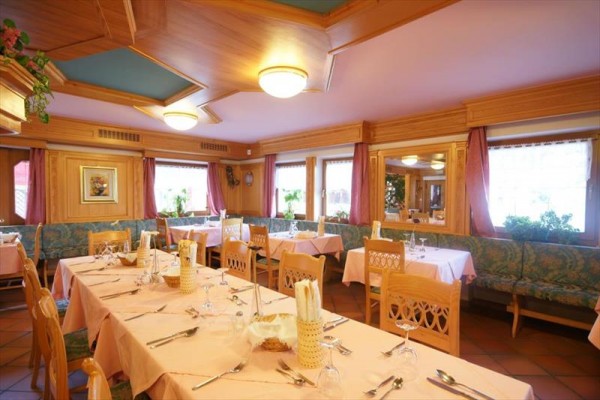 Stylová restaurace vyzdobená dřevem s prostřenými stoly.