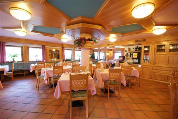 Elegantní restaurace s dřevěným interiérem a prostřenými stoly.