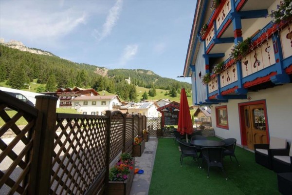 Terasa hotelu s květinami a výhledem na hory.