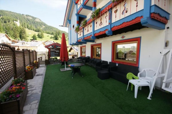 Venkovní teráska hotelu s barevnými dekoracemi a výhledem na kopce.