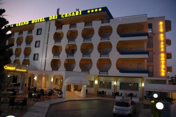 Večerní pohled na osvětlený hotel s názvem Grand Hotel dei Cesari.