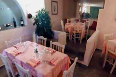 Restaurace s růžovými ubrusy na stolech a židlemi s opěradly.