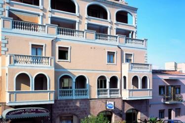 Budova hotelu s balkony a obloukovými okny.